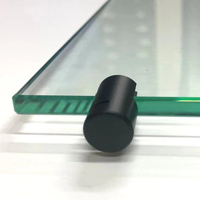 Black shelf clamp gripping the edge of a thick clear glass shelf