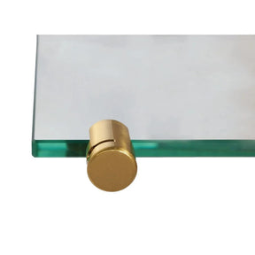Brass shelf clamp fitted to the corner of a clear glass shelf